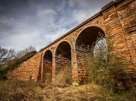 Substantial curved wing walls retain the approach embankments at both ends of the viaduct.