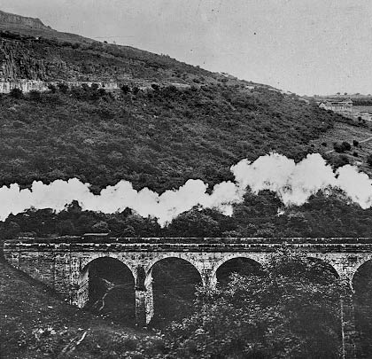 A collection of wagons are hauled across the viaduct.