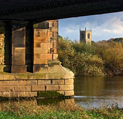 Torksey church peers over the trees at the viaduct's cutwaters.