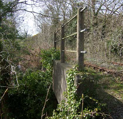 A simple concrete structure carries the track over a path.