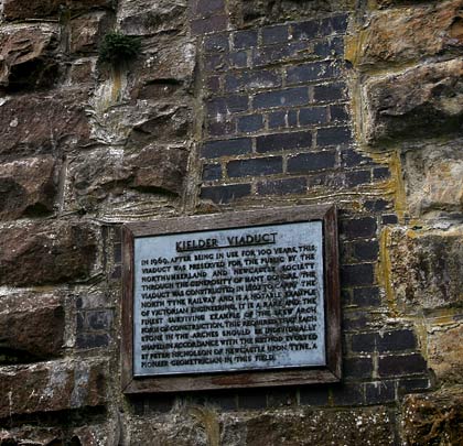 Remedial work has resulted in patches of engineering brick within the original stonework. A plaque recalls the viaduct's history.