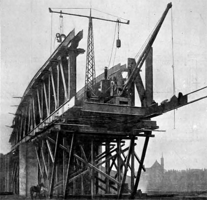 Stout timbers support the structure as the main span is extended outwards from both sides of the circular pier.