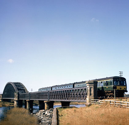 In the mid-60s, a Swindon DMU heads east over the river.